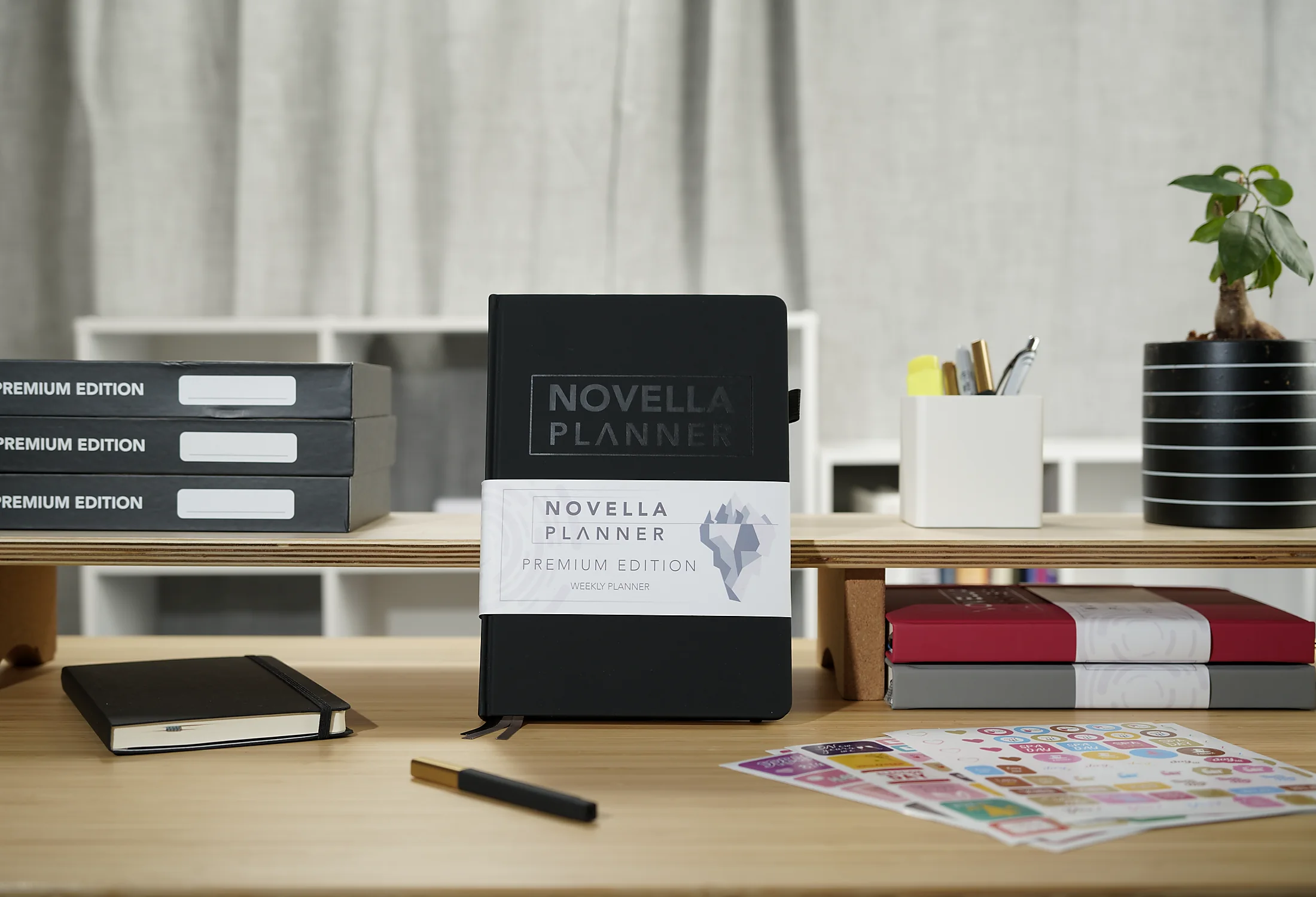Black Novella Planner staged on a desk with stationery and product materials